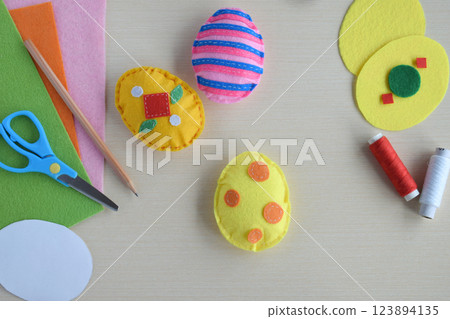 Making handmade easter eggs from felt with your own hands. Childrens DIY concept. Easter decoration Making handmade easter eggs from felt with your own hands. Childrens DIY concept. Easter decoration 123894135