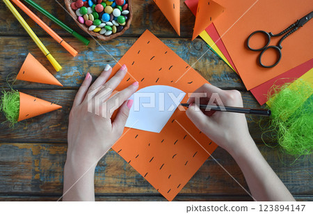 Carrots gift Bag for candies. DIY paper craft with your own hands together with children. Easter treat box. Art project for kids. Step by step guide. Carrots gift Bag for candies. DIY paper craft with your own hands together with children. Easter treat box. Art project for kids. Step by step guide. 123894147
