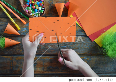 Carrots gift Bag for candies. DIY paper craft with your own hands together with children. Easter treat box. Art project for kids. Step by step guide. 123894148