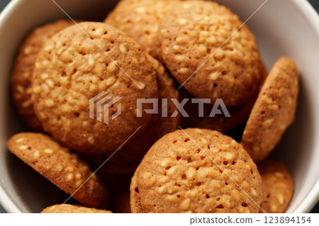 Freshly baked sesame cookies arranged in a white bowl ready for snacking or serving during afternoon tea Freshly baked sesame cookies arranged in a white bowl ready for snacking or serving during afternoon tea 123894154
