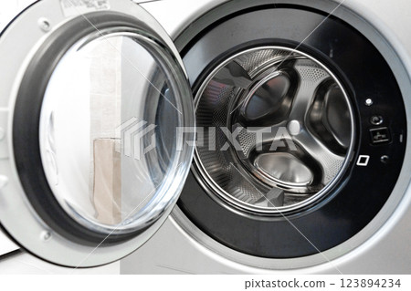 Washing machine with open door showcasing interior drum and control panel features for laundry tasks Washing machine with open door showcasing interior drum and control panel features for laundry tasks 123894234