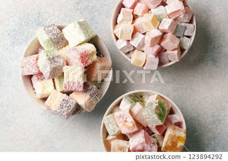 Colorful assorted Turkish delight sweets arranged in three bowls on a light surface with sugar coating Colorful assorted Turkish delight sweets arranged in three bowls on a light surface with sugar coating 123894292