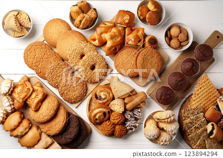 Delicious assortment of freshly baked cookies and pastries displayed on a wooden table 123894294