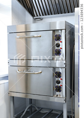 Stainless steel commercial oven setup in a modern kitchen with efficient design for food preparation 123894336