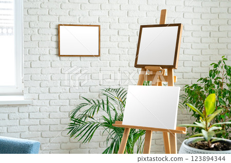 Art studio setup with empty canvas and fresh greenery surrounded by minimalist decor Art studio setup with empty canvas and fresh greenery surrounded by minimalist decor 123894344