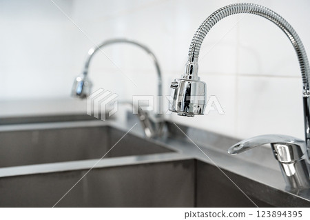 Modern kitchen sinks and faucets showcase sleek design and functionality in a contemporary environment with a minimalistic style 123894395
