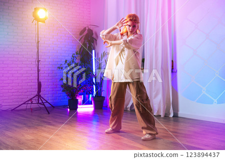 Dancer performing in a brightly lit studio with colorful lighting and plants during a creative rehearsal session Dancer performing in a brightly lit studio with colorful lighting and plants during a creative rehearsal session 123894437