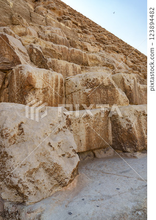 Exploring the ancient stone steps of the Great Pyramid near Giza under a clear blue sky 123894482