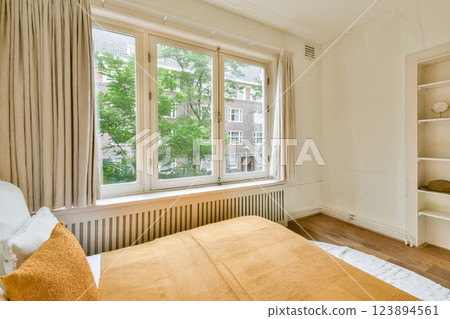 A warmly decorated interior showcasing large windows, soft textiles, and natural light, creating a serene and inviting atmosphere in a modern setting. 123894561