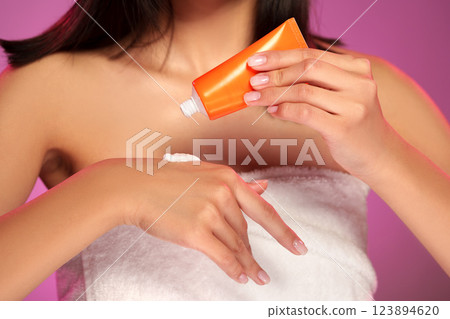 Applying body cream with care in a serene setting during a personal beauty routine Applying body cream with care in a serene setting during a personal beauty routine 123894620