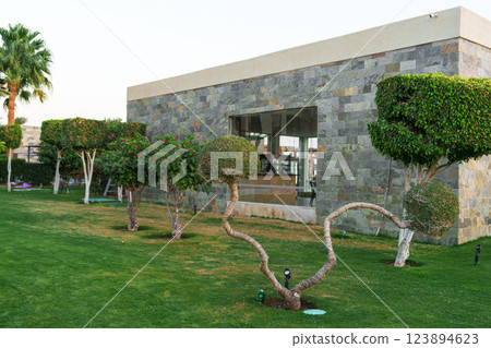 Modern stone building with manicured gardens in a desert location at sunset 123894623