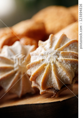 Delightful assortment of homemade meringue cookies displayed on a wooden platter during a cozy gathering Delightful assortment of homemade meringue cookies displayed on a wooden platter during a cozy gathering 123894816