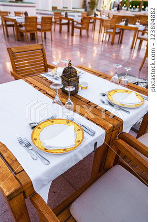 Elegant dining setup at an outdoor restaurant with beautifully arranged tables and glassware Elegant dining setup at an outdoor restaurant with beautifully arranged tables and glassware 123894882