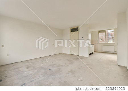 A spacious, empty room featuring white walls and a large window allowing natural light to flood in. The minimalistic design emphasizes simplicity. A spacious, empty room featuring white walls and a large window allowing natural light to flood in. The minimalistic design emphasizes simplicity. 123894923