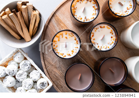 Aromatherapy candles, solid aroma oil in the form of peonies and palo santo displayed on wooden tray Aromatherapy candles, solid aroma oil in the form of peonies and palo santo displayed on wooden tray 123894941