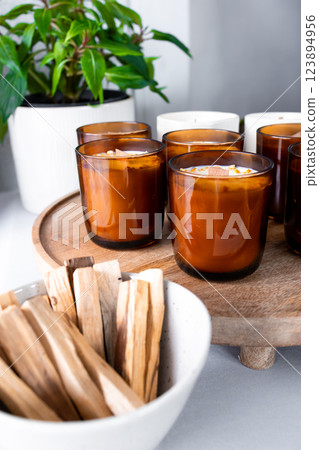 Aromatherapy candles and palo santo on wooden tray for relaxing ambiance 123894956