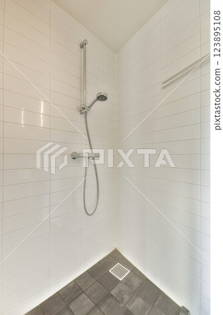 A minimalist shower area showcasing sleek tile designs and modern fixtures, perfect for contemporary bathroom aesthetics. A minimalist shower area showcasing sleek tile designs and modern fixtures, perfect for contemporary bathroom aesthetics. 123895108