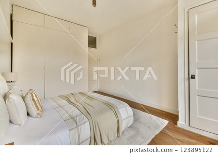 A serene modern bedroom featuring soft neutral tones, simple furnishings, and a cozy atmosphere that enhances relaxation and comfort. A serene modern bedroom featuring soft neutral tones, simple furnishings, and a cozy atmosphere that enhances relaxation and comfort. 123895122
