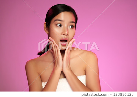 Woman expresses surprise against a vibrant pink background during a photo shoot in a studio setting Woman expresses surprise against a vibrant pink background during a photo shoot in a studio setting 123895123