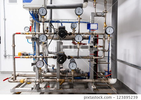 Complex industrial piping system with pressure gauges in a modern facility 123895239