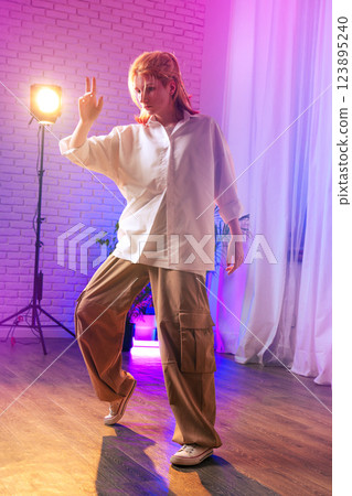 Dynamic dance performance by a woman in bright lighting during an indoor show 123895240