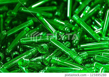 Bright green plastic vials scattered on a surface, showcasing their unique shapes and vibrant colors in a creative display Bright green plastic vials scattered on a surface, showcasing their unique shapes and vibrant colors in a creative display 123895280