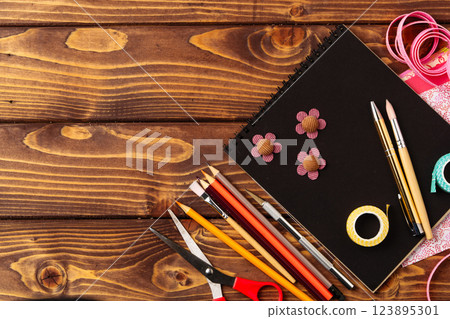 Creative crafting workspace with various tools laid out on a wooden table for a fun project 123895301