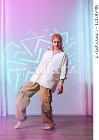 Dance performance with colorful lighting in modern studio setting during evening hours 123895489