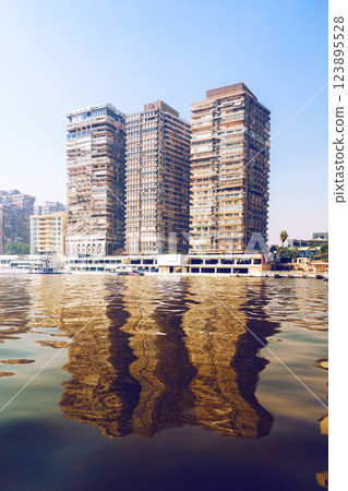 Reflections of modern architecture on a calm river in Cairo showcasing vibrant city life and urban development Reflections of modern architecture on a calm river in Cairo showcasing vibrant city life and urban development 123895528