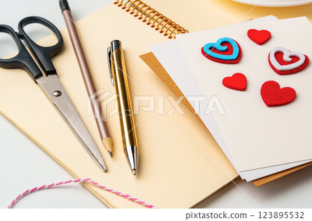 Creative workspace for making handmade greeting cards with colorful hearts and stationery Creative workspace for making handmade greeting cards with colorful hearts and stationery 123895532