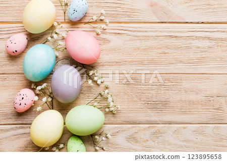 Happy Easter composition. Easter eggs on colored table with gypsophila. Natural dyed colorful eggs background top view with copy space Happy Easter composition. Easter eggs on colored table with gypsophila. Natural dyed colorful eggs background top view with copy space 123895658