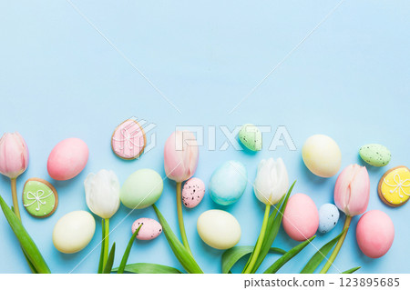 Happy Easter composition. Easter eggs on colored table with yellow Tulips. Natural dyed colorful eggs background top view with copy space Happy Easter composition. Easter eggs on colored table with yellow Tulips. Natural dyed colorful eggs background top view with copy space 123895685