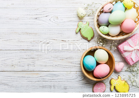 Easter frame with eggs, gift box and tulip on a colored background. The minimal concept. Top view Happy Easter composition. Card with a copy space of the place for the text 123895725