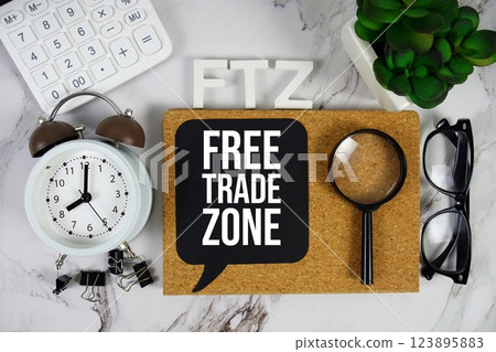 FTZ - Free Trade Zone acronym with calculator, alarm clock and magnifying glass, Business and Financial concept background 123895883