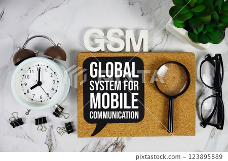 GSM Global System for Mobile communication acronym with alarm clock and magnifying glass, business concept background 123895889