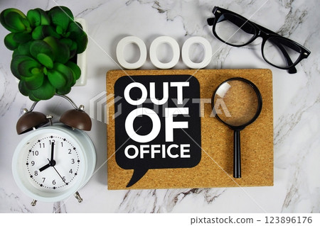OOO - Out of Office acronym with alarm clock and magnifying glass, business concept background 123896176