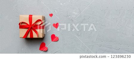 Valentine day composition: red gift box with bow and heart. Christmas present. View from above. Space for text. Holday greeting card 123896230
