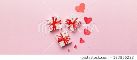 Valentine day composition: red gift box with bow and heart. Christmas present. View from above. Space for text. Holday greeting card Valentine day composition: red gift box with bow and heart. Christmas present. View from above. Space for text. Holday greeting card 123896288