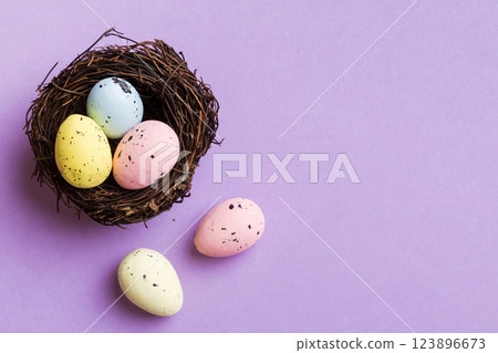 Colorful easter eggs in nest on table background with copy space top view Colorful easter eggs in nest on table background with copy space top view 123896673