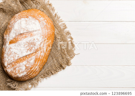 Freshly baked delicious french bread with napkin on rustic table top view. Healthy white bread loaf 123896695