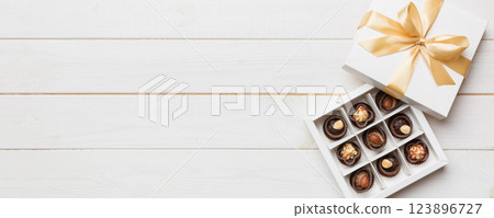 White box with chocolates candies and golden tape. top view with copy space 123896727