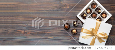 White box with chocolates candies and golden tape. top view with copy space 123896728