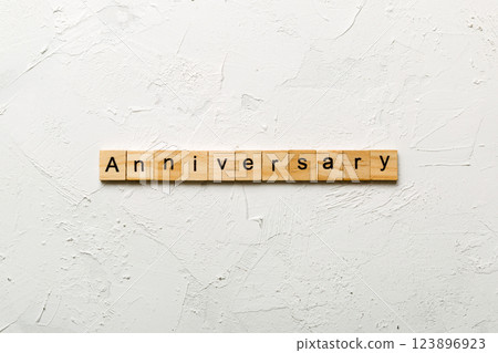 anniversary word written on wood block. anniversary text on cement table for your desing, concept anniversary word written on wood block. anniversary text on cement table for your desing, concept 123896923