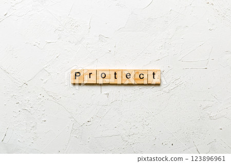 PROTECT word written on wood block. PROTECT text on cement table for your desing, concept 123896961