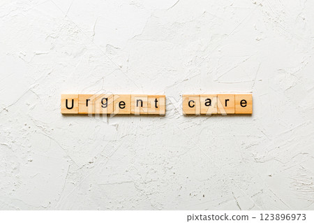 Urgent care word written on wood block. Urgent care text on cement table for your desing, concept Urgent care word written on wood block. Urgent care text on cement table for your desing, concept 123896973