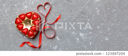 Delicious chocolate pralines in red box for Valentine's Day. Heart shaped box of chocolates top view with copy space Delicious chocolate pralines in red box for Valentine's Day. Heart shaped box of chocolates top view with copy space 123897204
