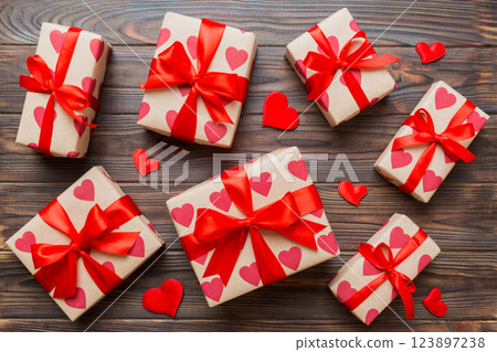 Top view photo of valentine day decorations gift box with red ribbon bow on colored background. Holiday gift boxes with top view 123897238
