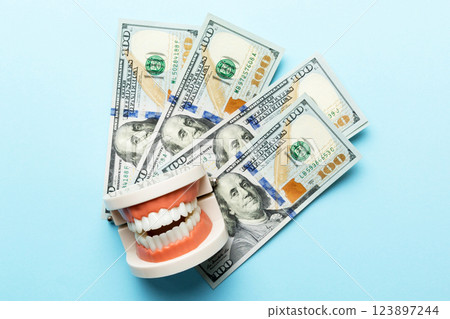 Closeup model of a human jaw with white teeth and dollar bill. Dentistry conceptual photo. Prosthetic dentistry. False teet top view with copy space Closeup model of a human jaw with white teeth and dollar bill. Dentistry conceptual photo. Prosthetic dentistry. False teet top view with copy space 123897244