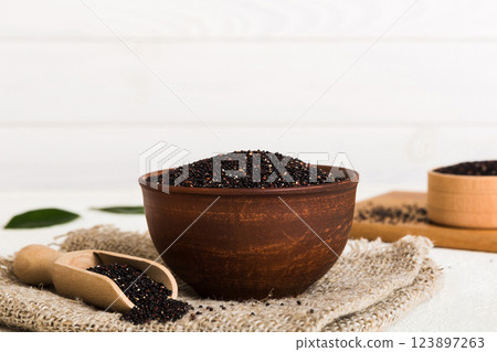 quinoa seeds in bowl and spoon on colored background. Healthy kinwa in small bowl. Healthy superfood 123897263