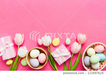 Easter frame with eggs, gift box and tulip on a colored background. The minimal concept. Top view Happy Easter composition. Card with a copy space of the place for the text Easter frame with eggs, gift box and tulip on a colored background. The minimal concept. Top view Happy Easter composition. Card with a copy space of the place for the text 123897628